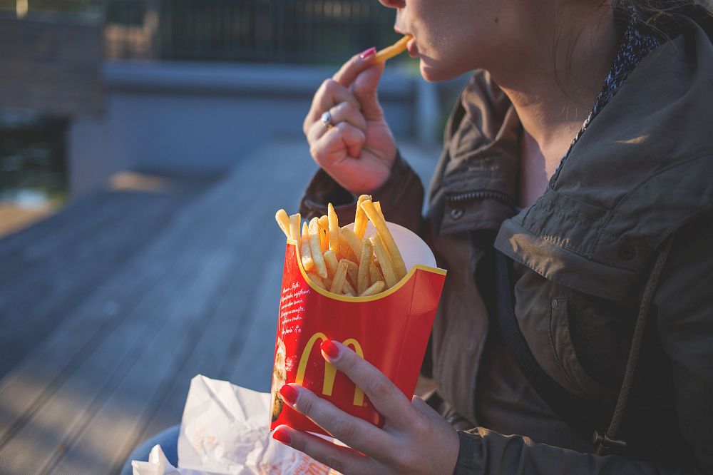A woman eating fast food french fries