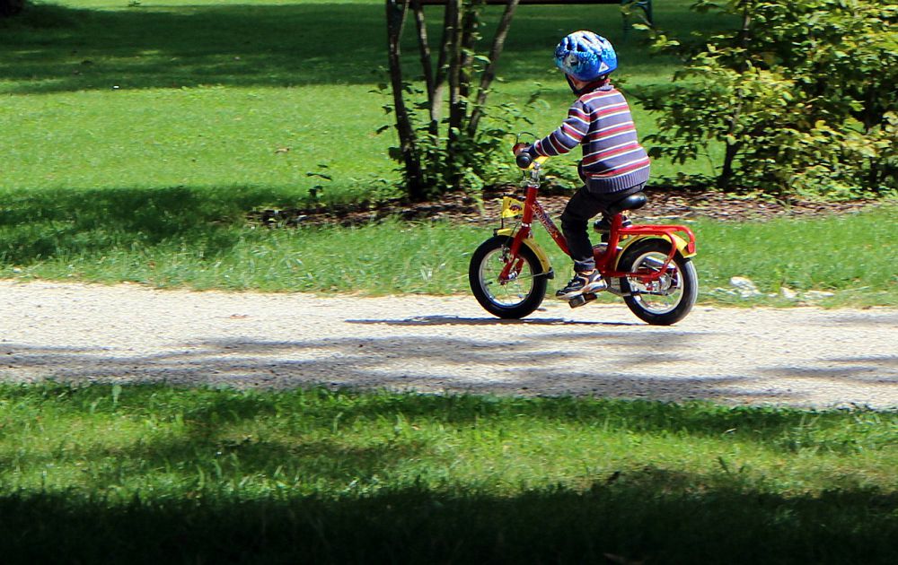 A child riding a bike, wearing a helmet