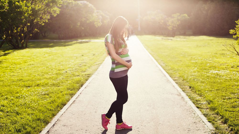 A young pregnant woman holding her tummy